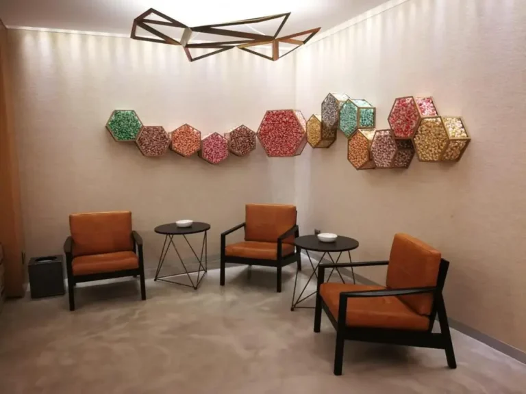there are three chairs and a table in a room with a wall hanging