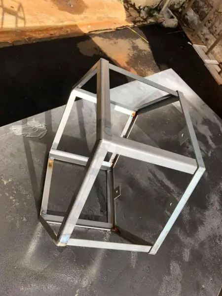 a close up of a metal object on a table with a piece of wood