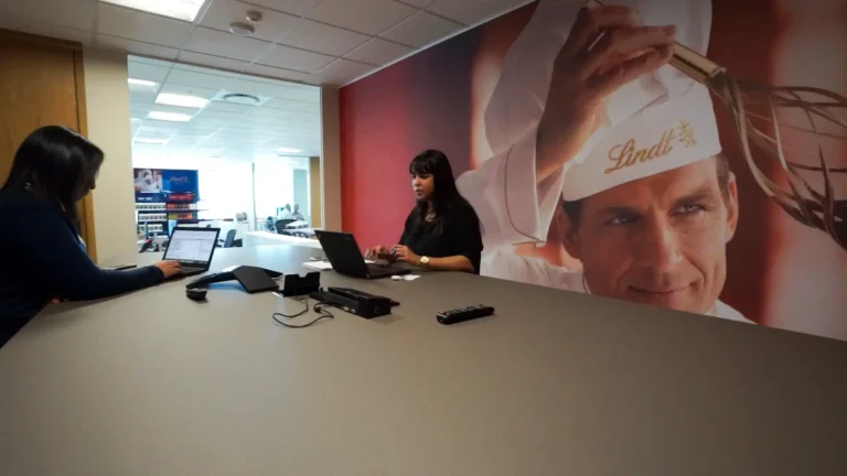 there are two women sitting at a table with laptops