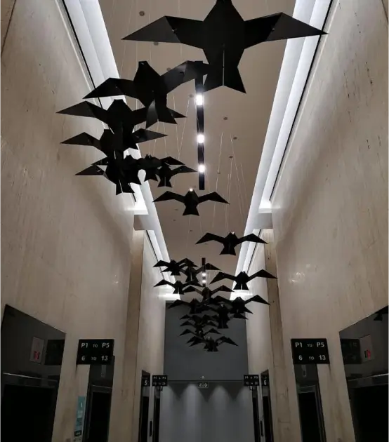 there are many black birds hanging from the ceiling of a building