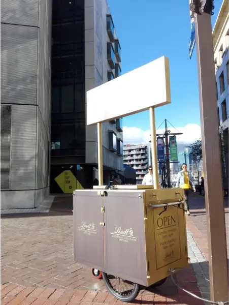 there is a cart with a sign on it sitting on the sidewalk