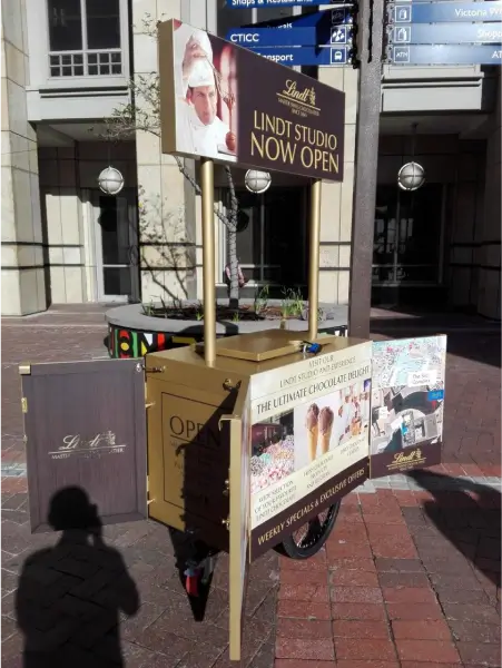 there is a cart with a sign on it on the sidewalk