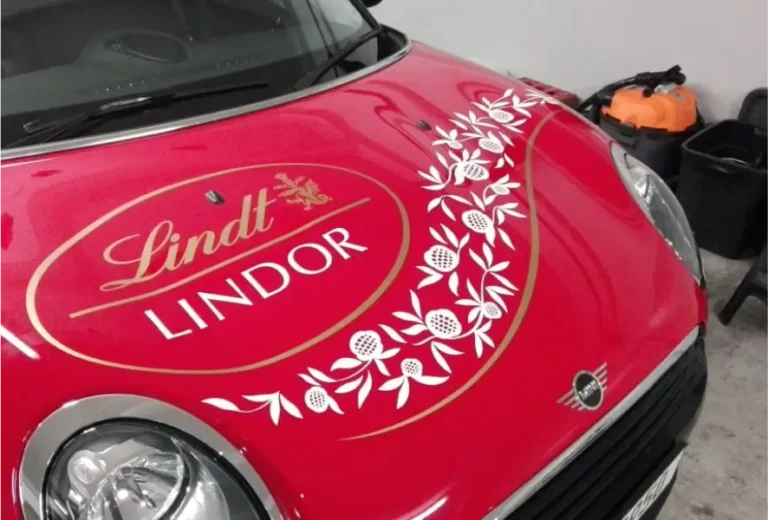 a close up of a red car with a gold logo on it