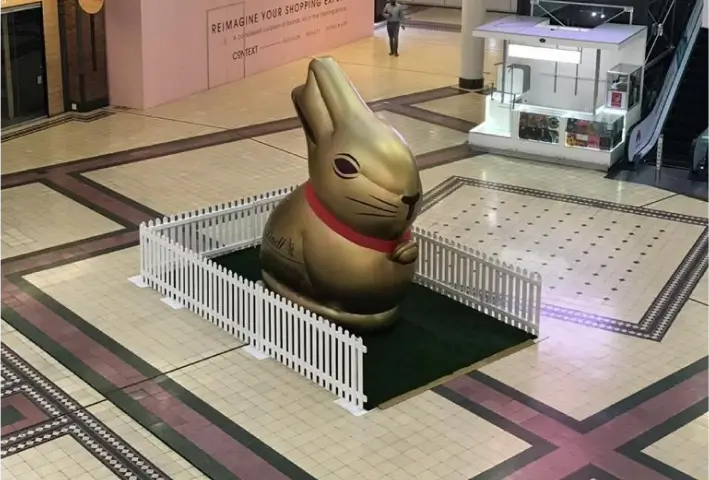 there is a large chocolate bunny statue in a mall lobby