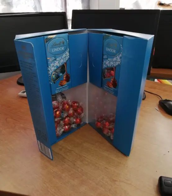 there is a blue box with candy inside of it on a table