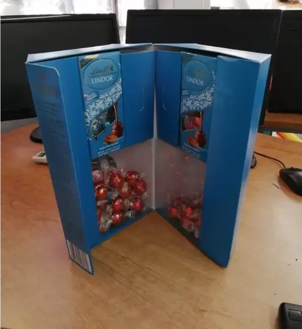 there is a blue box with candy inside of it on a table