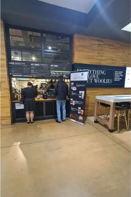 people are standing in line at a counter in a store