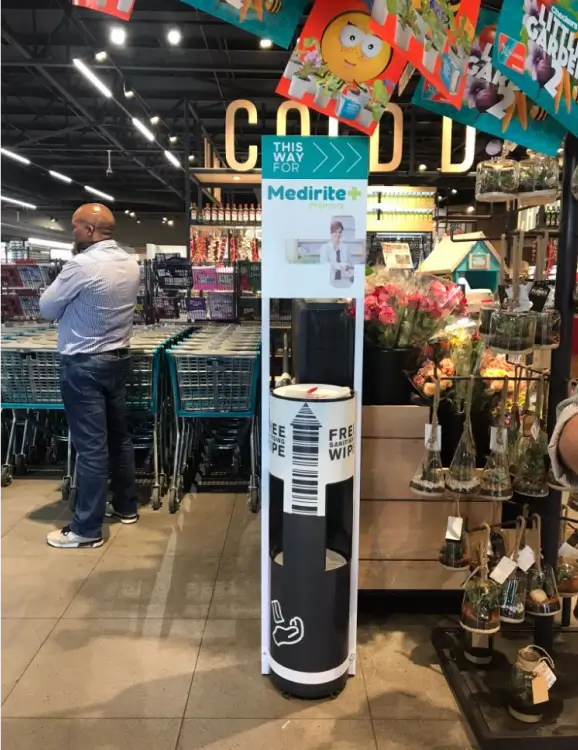there is a man standing in a store with a water cooler
