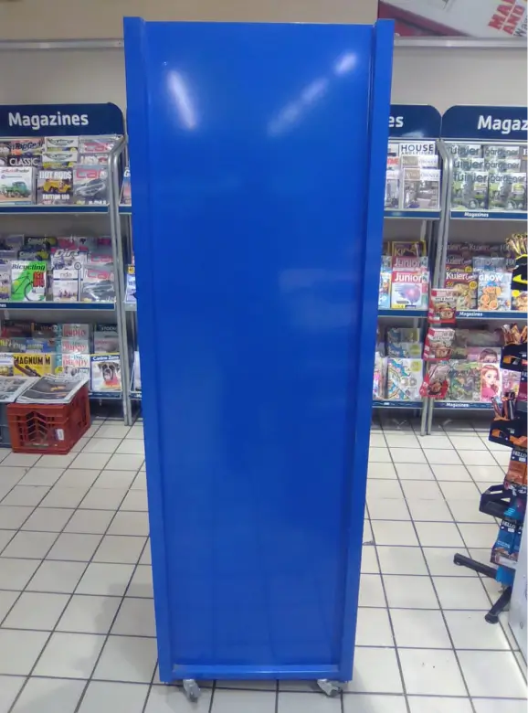 a close up of a blue refrigerator in a store with shelves of magazines