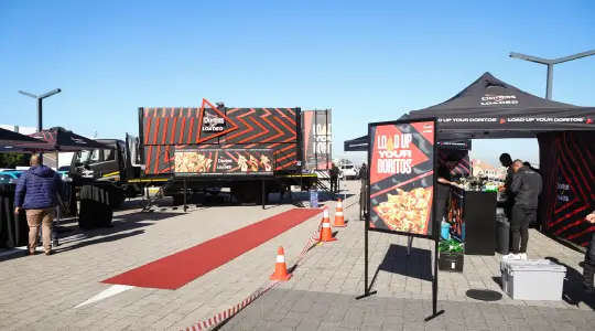 people standing around a food truck with a red carpet