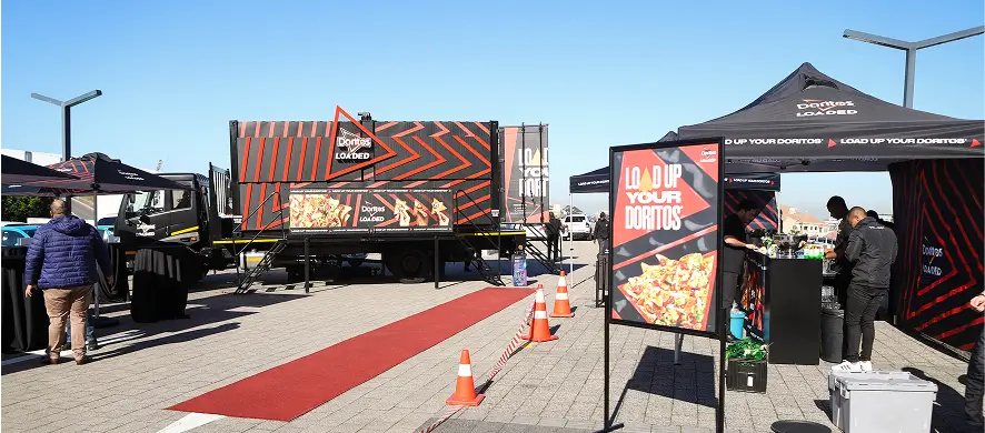 people are standing around a food truck with a red carpet