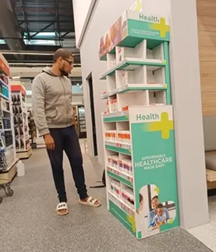 there is a man standing in a store looking at a shelf