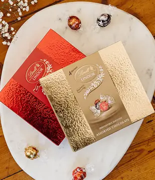 a close up of a plate with chocolates and a box of candy